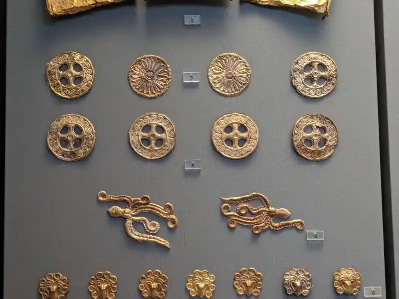 Closer view of gold rosettes and marine-themed cut-outs from Grave III, Mycenae